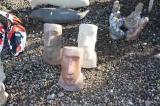 Three concrete garden ornaments in the form of Easter Island heads