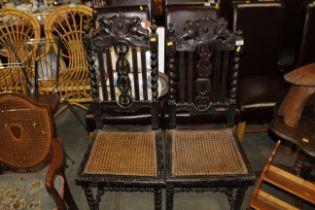 A pair of Victorian carved oak cane seated chairs