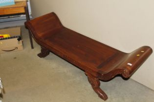 A carved wooden scroll end bench