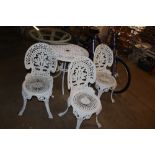 An ornate white painted garden table and three cha