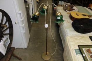 A brass three branch lamp with green glass shades