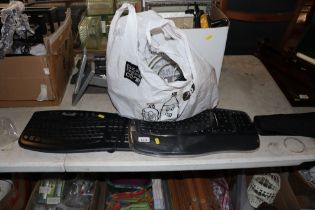 Two computer keyboards and bag of various leads
