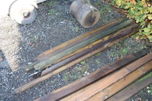 A quantity of wooden and metal garden posts