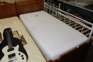 A pine framed single trundle bed with mattresses