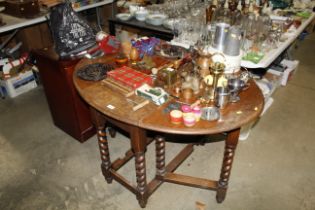 An oak gate leg table raised on barley twist suppo