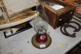 A brass and cranberry glass oil lamp