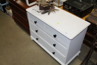 A white chest of two short and two long drawers