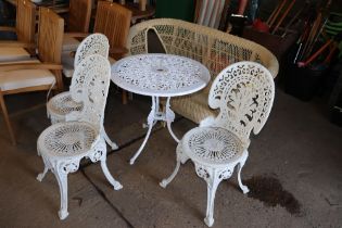 An ornate white painted metal garden table and thr
