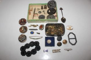 A box containing various buttons, buckle, brooches