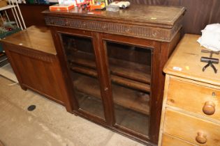 An oak and glazed cabinet with three adjustable sh