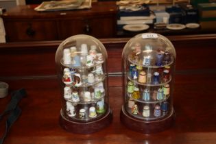Two collections of thimbles contained under glass