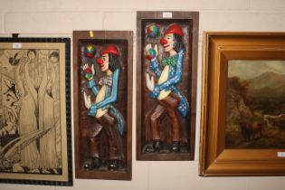 Two painted wooden plaques depicting clowns