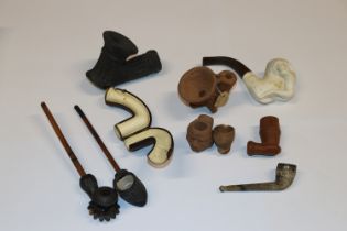 A box of carved wooden, pottery and Meerschaum pipes