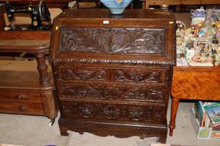 A carved oak bureau fitted two short over two long