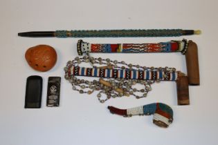 A box containing beadwork decorated pipes, lighter