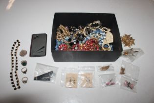 A box of decorative jewellery, dress rings, brooch