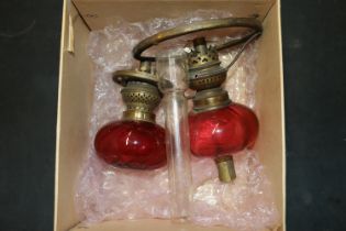 A box containing cranberry glass oil lamp parts