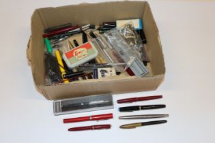 A box containing various fountain pens, pen parts