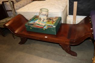 A carved wooden scroll end bench