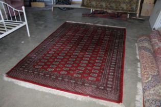 An approx. 9' x 6'4" red Eastern patterned rug