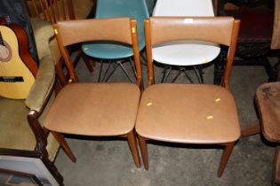 A pair of teak dining chairs