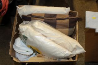 A box containing various cushions, pillows, duvets