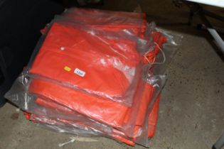 A quantity of orange coloured overcoats