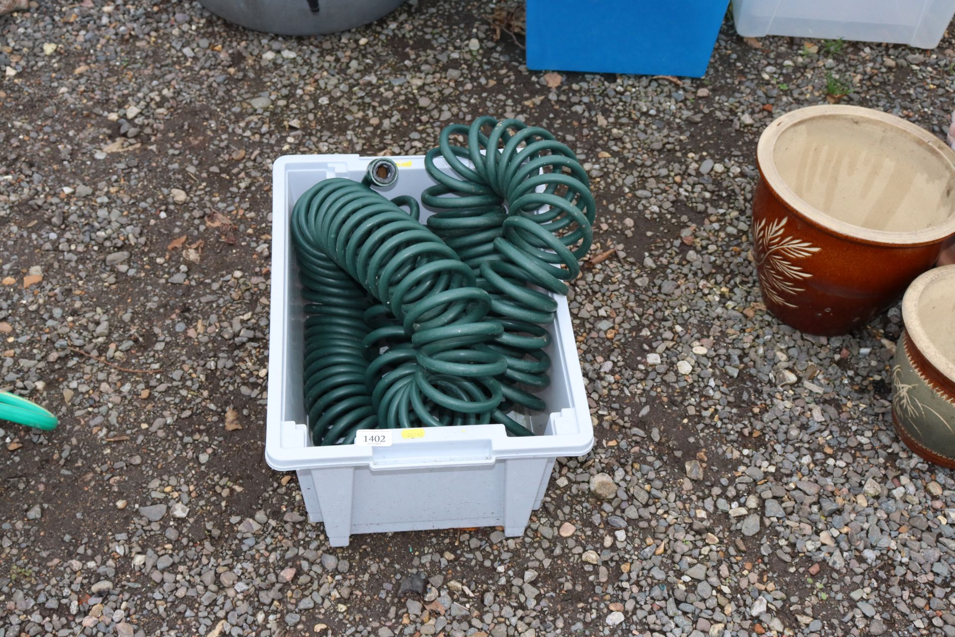 A plastic crate containing a hose pipe