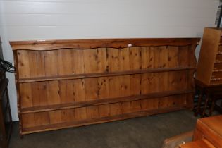 A large stripped pine wall shelf