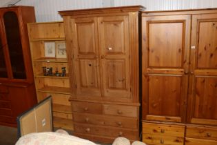 A stripped pine wardrobe fitted with two short ove