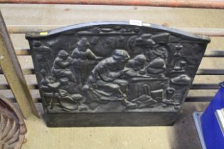 A painted cast iron wall plaque depicting a househ