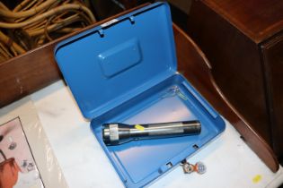 An LED torch together with a Vanguard cash tin and