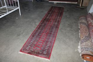 An approx. 12'8" x 2'7" Eastern patterned red and