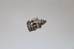 A white metal brooch in the form of a sailing ship