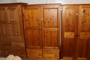 A modern pine two door wardrobe fitted four drawer