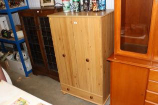 A pine effect wardrobe fitted single drawer below