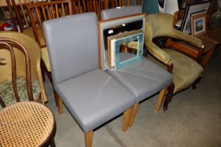 A pair of faux leather upholstered dining chairs