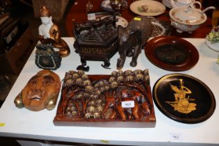 A wooden plaque depicting elephants, carved wooden