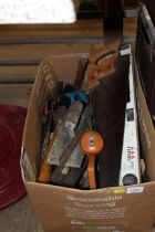 A box containing various hand tools to include saw