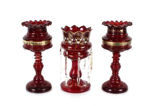 A pair of Victorian ruby glass lustre vases, decorated with a band of enamelled flowers raised on
