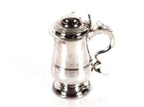 A George III silver lidded tankard, the body with family crest and central gridle, the scrolled