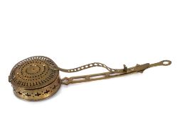 An antique brass chestnut roaster, with pierced decoration and locking handle, 58cm long