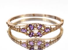 A 9ct gold diamond and amethyst set bangle, the central pearl surrounded by an arrangement of four