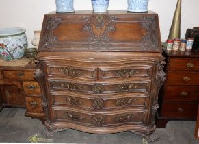 A large 19th Century continental carved rosewood bureau, the fall front opening to reveal an