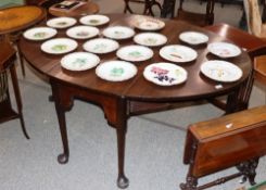 A 19th Century mahogany pad foot dining table, the oval drop leaves raised on swing supports,