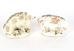 A pair of early 19th Century porcelain figures of boars, on naturalistic flower and acorn strewn