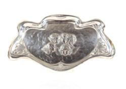 An Edwardian Art Nouveau silver tray, decorated angels heads within floral borders and shaped