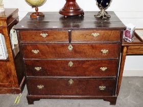 An 18th Century oak chest, of two short and three long graduated drawers raised on bracket feet