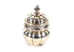 A Victorian silver tea caddy, the domed hinged lid surmounted by a flower finial, foliate chasing to