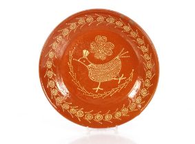 A large antique slipware circular bowl, decorated with a naïve chicken and flowers, 35cm dia.